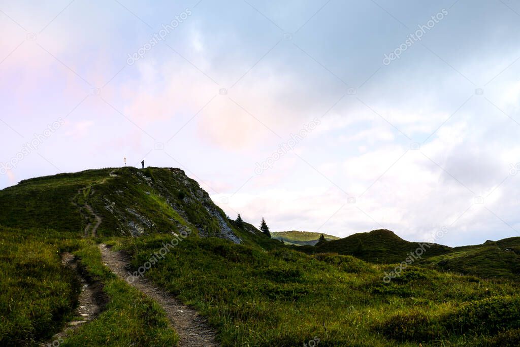 A lonely hiker on top of a peak in the Beverin national park, in Switzerland