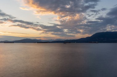 Vancouver 'ın önünde günbatımında konteynır gemileri, yelkenli tekneleri ve stand-up kürekleri vardı.