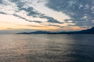 Vancouver 'ın önünde günbatımında konteynır gemileri, yelkenli tekneleri ve stand-up kürekleri vardı.
