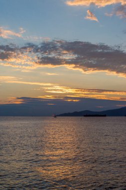 Vancouver 'ın önünde günbatımında konteynır gemileri, yelkenli tekneleri ve stand-up kürekleri vardı.