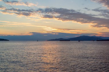 Vancouver 'ın önünde günbatımında konteynır gemileri, yelkenli tekneleri ve stand-up kürekleri vardı.