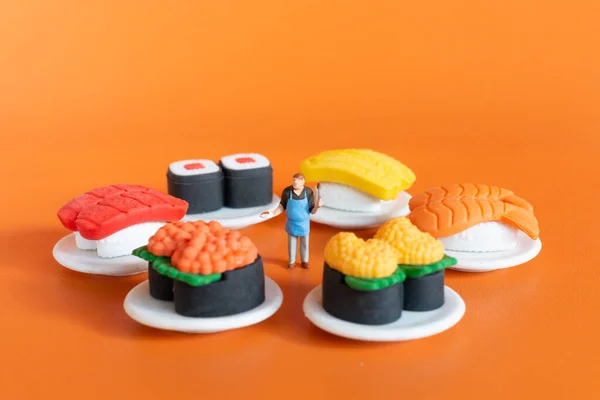 Miniaturní Lidé Kuchař Dělat Sushi Nastavit Oranžovém Pozadí — Stock fotografie