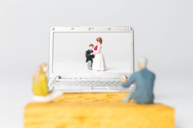 Miniature people Bride and groom virtual wedding on computer screen, Happy Valentines Day concept