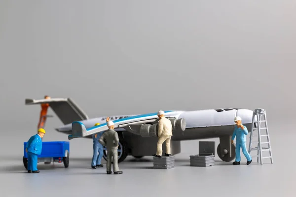 Miniatyr Människor Arbetare Team Kontrollera Och Reparera Flygplan Grå Bakgrund — Stockfoto