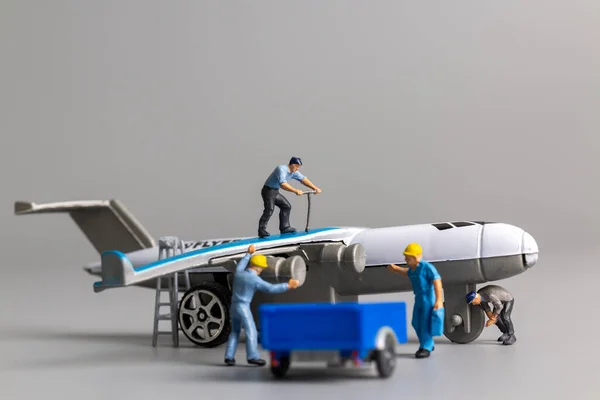 Equipo Trabajadores Miniatura Revisando Reparando Avión Sobre Fondo Gris — Foto de Stock