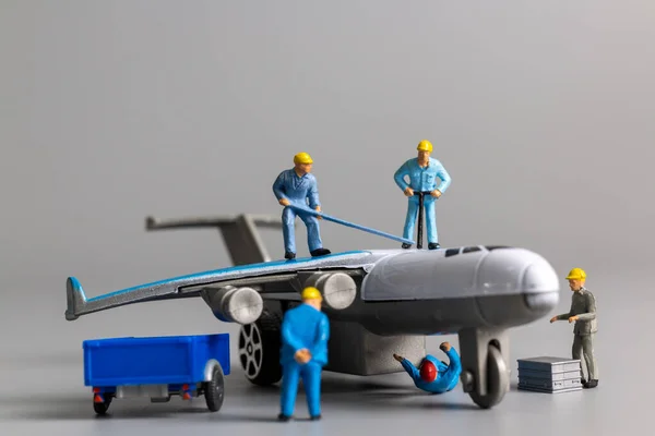 Equipo Trabajadores Miniatura Revisando Reparando Avión Sobre Fondo Gris — Foto de Stock