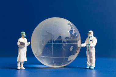 Minyatür insanlar. Doktor ve hemşire küresel sağlık hizmetlerini, dünya çevresi gündüz konseptini kontrol ediyorlar.