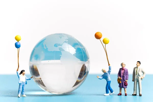 用水晶球抱气球的迷你人 世界环境日的概念 — 图库照片