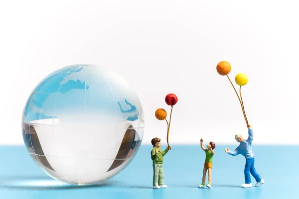 用水晶球抱气球的迷你人 世界环境日的概念 — 图库照片
