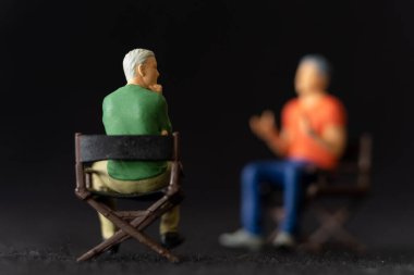 Minyatür insanlar terapist ve hasta birlikte konuşuyor. Stresli bir durumla başa çıkması için ona yardım ediyor.