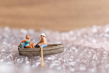 Miniature people ,Couple with boat sailing on pink bubble