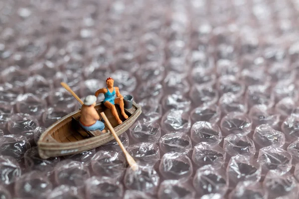 Miniature people ,Couple with boat sailing on pink bubble