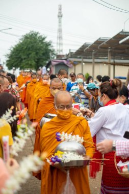 Songkhla Buri, Kanchanaburi, Tayland - 26 Haziran 2022: Budist rahipler sabah erken saatlerde yerel halktan sadaka ve yiyecek alıyorlar.