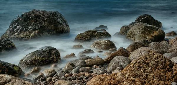 Морские волны и скалы на пляже — стоковое фото