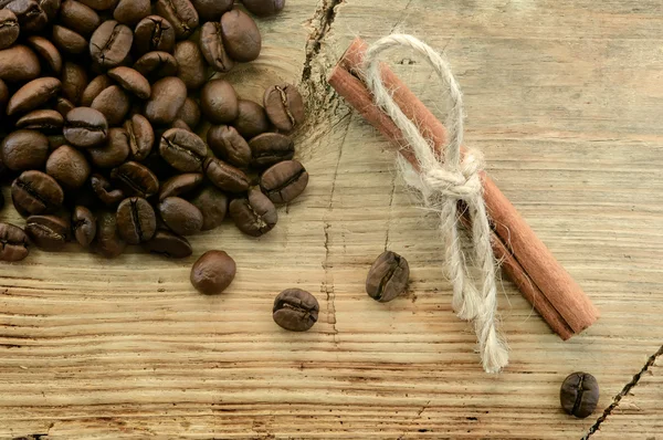 コーヒー豆と木製の背景にシナモン — ストック写真