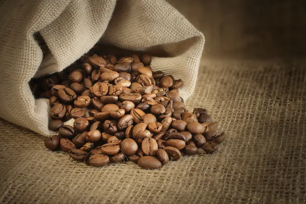 Chicchi di caffè torrefatto fuoriuscita dalla borsa — Foto Stock