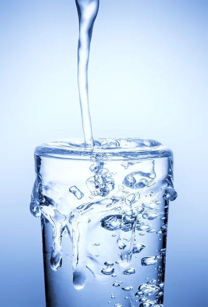 Water gieten in glas geïsoleerd, close-up — Stockfoto