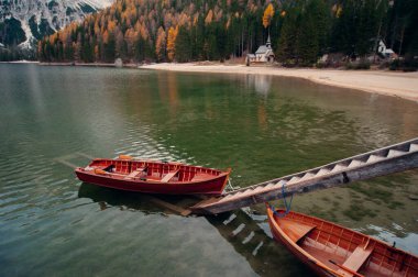 Dolomiti dağlarındaki Lago di Braies Gölü 'nün muhteşem manzarası. Göl kenarındaki meşhur ahşap kayıklar. Güney Tyrol, İtalya.
