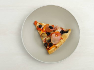 Pizza, şeffaf arka planda gri bir tabakta bir dilim pizza. Jambon ve peynirli, zeytinli, mantarlı ve domatesli. Üst Manzara. Metin için boşluk.