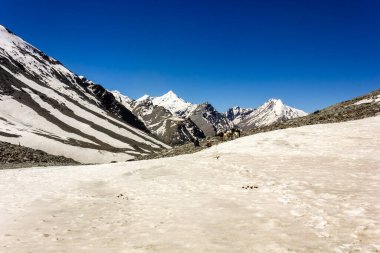 Shingo La geçidi yakınlarındaki Zanskar sıradağlarının Himalaya dağları karla kaplı bir tepenin yoğun karları arasından geçen bir patika..