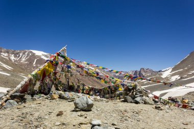 Zanskar, India - July 2012: Colorful tibetan Buddhist prayer flags on top of the high altitude pass of Shingo La over the Great Himalayan range in Zanskar.