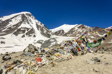 Zanskar, India - July 2012: Colorful tibetan Buddhist prayer flags on top of the high altitude pass of Shingo La over the Great Himalayan range in Zanskar.
