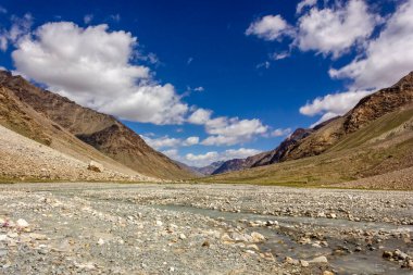 Kargyak Nehri 'nin geniş nehir yatağı Zanskar Dağları' nın dağları ve Hint Himalaya 'sında Darcha Padum yürüyüş rotasında mavi bir gökyüzü..