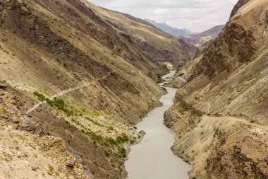 Zanskar 'da vahşi bir yolda derin ve kayalık bir kanyondan akan bir nehir..
