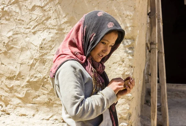 Zanskar, Hindistan - Temmuz 2012: Zanskar 'da bir köyde kır çamurlu evinin önünde duran genç bir Hintli kızın samimi portresi.