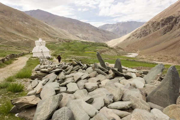 Zanskar, Hindistan - Temmuz 2012: Hint Himalayaları 'nın Ladakh kentindeki Zanskar bölgesinde bir köye giden uzun bir Tibet Budist Manikür Taşları Duvarı.