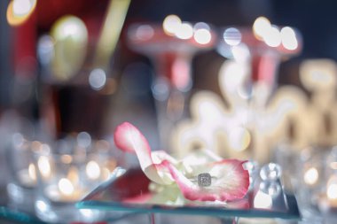 Altın yüzük, kırmızı kutuda alyans ve beyaz-kırmızı arka planda kırmızı kalp ve güzel bir bokeh. Düğün anı, yıldönümü, nişan, ya da Sevgililer Günü. Mutlu gün