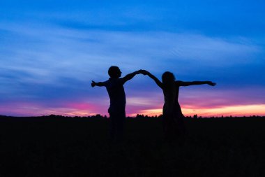 Gün batımında siluetli aşk çifti
