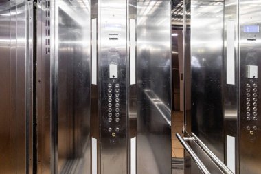 Asansör girişi modern ofiste mermer duvarlı. Ulaşım katını yukarı ve aşağı itme düğmesi ile katlara taşı