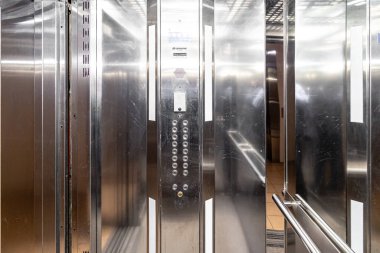 Asansör girişi modern ofiste mermer duvarlı. Ulaşım katını yukarı ve aşağı itme düğmesi ile katlara taşı