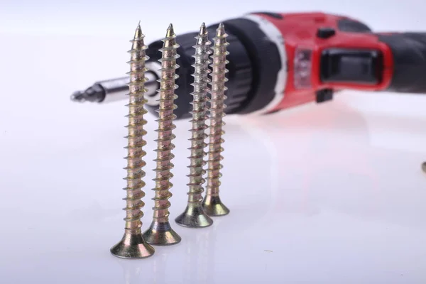 Pille çalışan bir tornavida tabancası matkabı beyaz arkaplan metin üzerinde bir yığın vida yanında veya kopyalama alanı sağ, ev geliştirme inşaat DIY yeniden modelleme güç aracı kavramı, yatay çekim