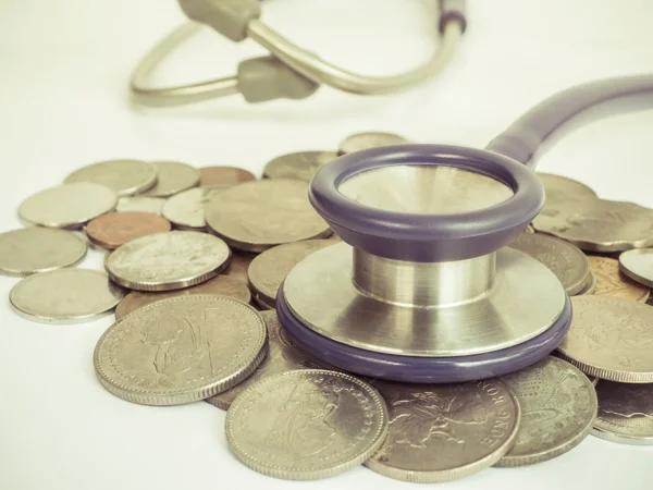 Stethoscope and coins vintage style — Stock Photo, Image