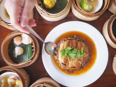 Çin yemeğinin en üst görüntüsü. Beyaz tabakta hardal yeşili ile pişirilmiş domuz göbeği..