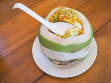 Tayland usulü körili deniz ürünleri ezmesi ya da kahverengi ahşap masada hindistan cevizi ve beyaz kaşık..