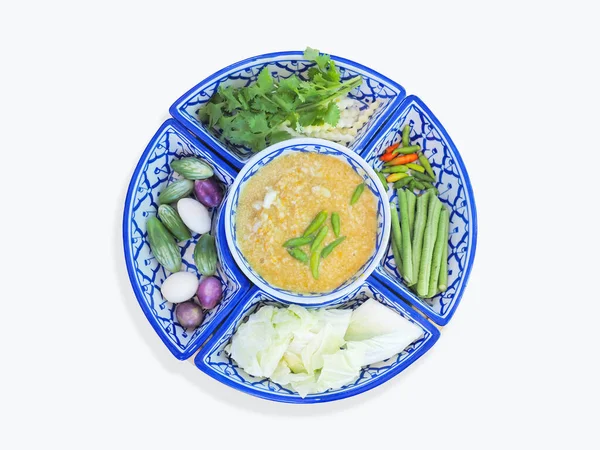 Crab chili paste dip with coconut milk with fresh vegetables on tradition blue and white plate.