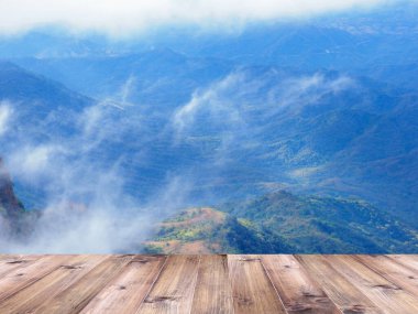 Yeşil dağın üzerindeki ahşap masa ve bulanık arka plan. Ürünü görüntülemek için kurgu biçimi.