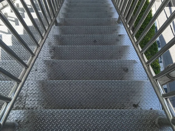 Stainless steel overpass stairs flyover with floor texture pattern across the street.