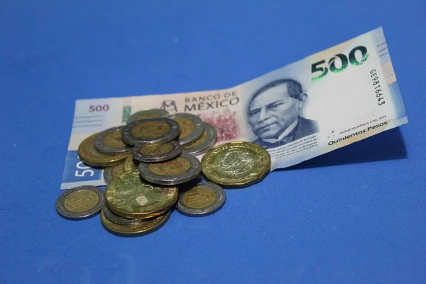 墨西哥面值500比索的钞票和堆积起来的硬币放在桌上 — 图库照片