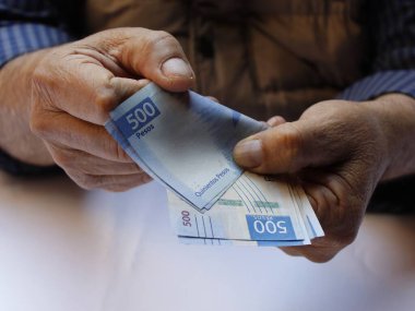 Meksika banknotlarını tutan ve sayan yaşlı bir adamın elleri