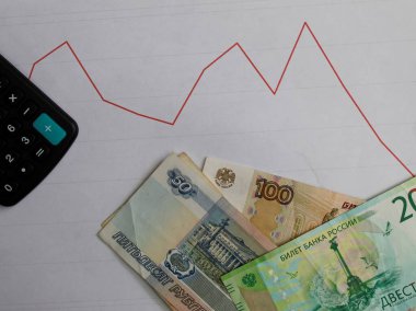 Aşağı yönlü bir grafikte Rusya 'nın banknotları ve hesap makinesi