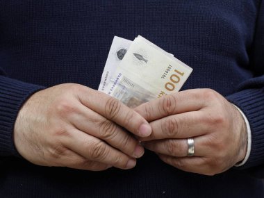 Danimarka banknotları tutan bir adamın elleri.