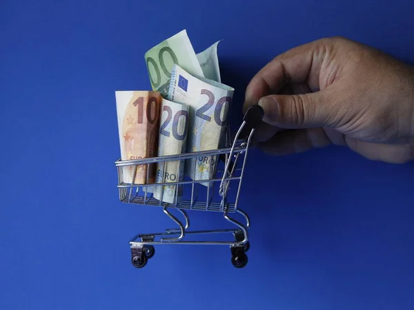 Hand Van Een Man Met Een Winkelwagentje Met Europese Biljetten — Stockfoto