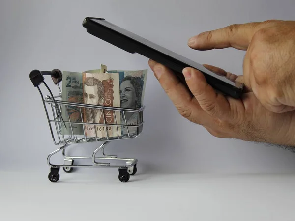 Hand Met Een Smartphone Colombiaanse Biljetten Een Winkelwagen — Stockfoto