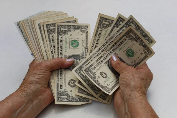 手里拿着和数着美元钞票的老年妇女的手 — 图库照片