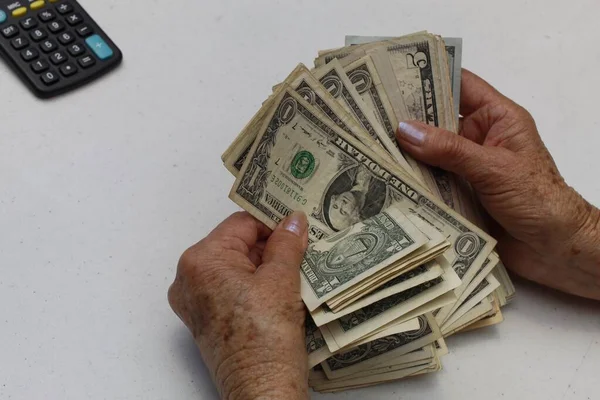 手里拿着和数着美元钞票的老年妇女的手 — 图库照片
