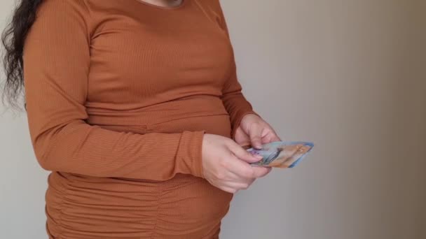 妊娠中の女性がニュージーランドの銀行券を持ち — ストック動画
